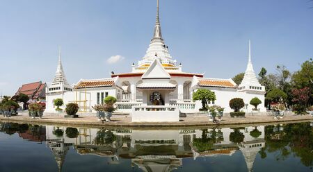 Thai Buddhist temple Wat Khan Lad is surrounded by a pond of water in Bangkok, Thailandの写真素材