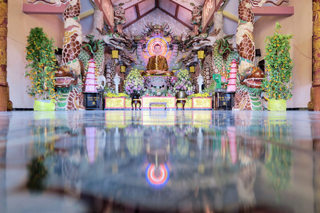 Sitting Buddha on altar is reflected on the marble floor at a Mahayana Buddhist temple in Dalat, Vietnamのeditorial素材