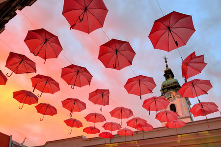 colorful urban art, umbrellas whimsically suspended in front of a church, at duskの写真素材