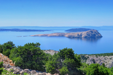 Hills overlook the islands and deep blue water of the Adriatic sea near Senj, Croatiの写真素材