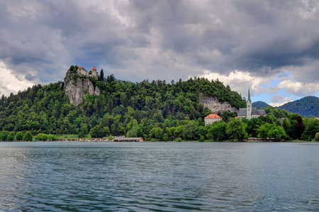 Bled Island, Bled Castle, and the pilgrimage church dedicated to the Assumption of Mary on an overcast day; Lake Bled, Slovenia.のeditorial素材