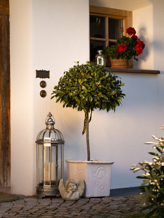 nice diy deco in front of an old front door  containing lantern, standart laurel tree, angelの写真素材