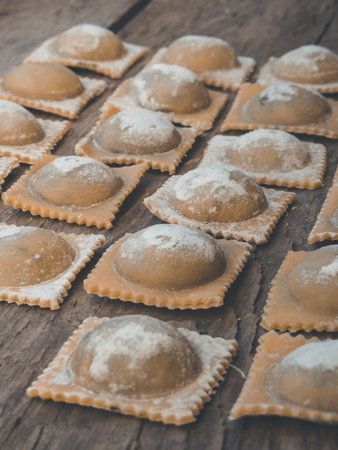 organic traditional pasta and ravioli handmade vegan filled with spinach and ricotta, on wooden...