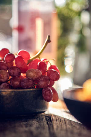 Small bowl filled with grapes in the sunの写真素材