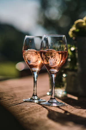 Two glasses of rose wine on wooden tableの写真素材