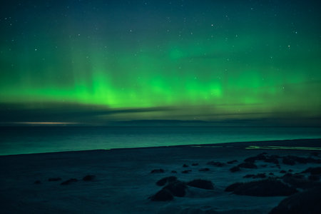 Green Northern Lights dancing over beachの写真素材
