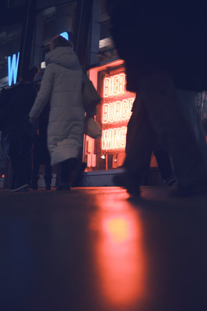 Beer Burger Wings neon sign at night on busy streetの写真素材