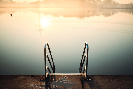 Ladder into lake in morning sunlightの写真素材