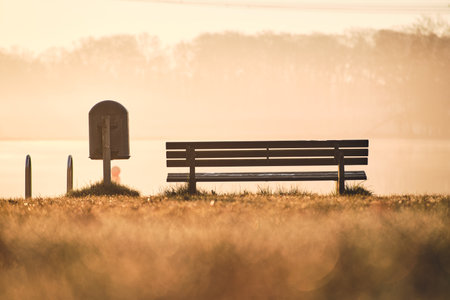 Bench at bathing area at lake in the morningの写真素材