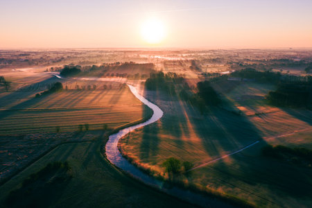Sunrise over river on misty morningの写真素材
