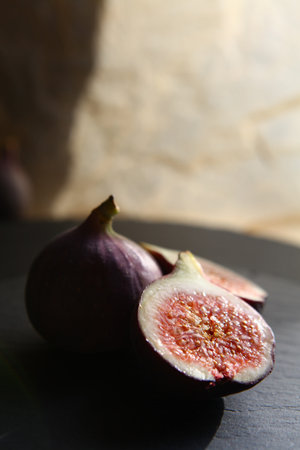 Purple figs on a black stone plate. Photo, background with fresh, juicy, ripe tropical fruits....