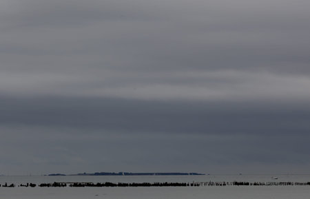 The dramatic gloomy sky over the peaceful sea