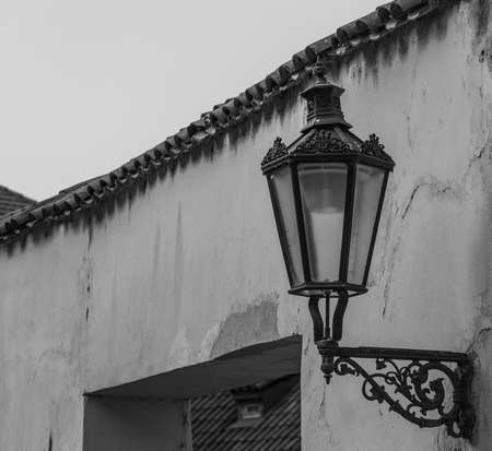 A vintage street lamp mounted on the wall of an old buildingの写真素材