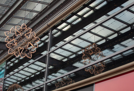 Hanging an electric garland in the shape of a snowflake. It is a Christmas decoration. Its reflection is visible in a window.の写真素材