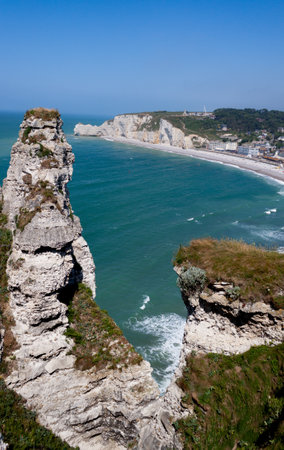 The white cliffs, the blue sky, the emerald green sea, the beach and the tourist village of Etretat.の写真素材