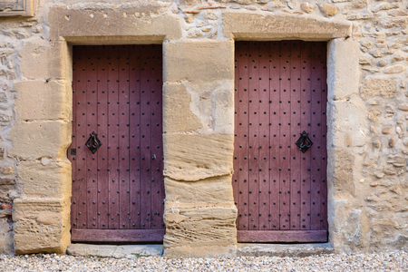 Old reddish door on a castle stone wall.の写真素材