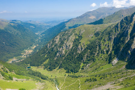Aerial perspective of Espone Valley reveals steep forested slopes, rugged cliffs, and a winding...