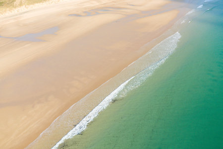 Aerial image of Plage de la Vieille eglise shows gentle waves meeting smooth, wide sand with tidal...