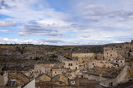 A panoramic view of Matera, Italy, reveals weathered stone rooftops and clustered historic buildings...