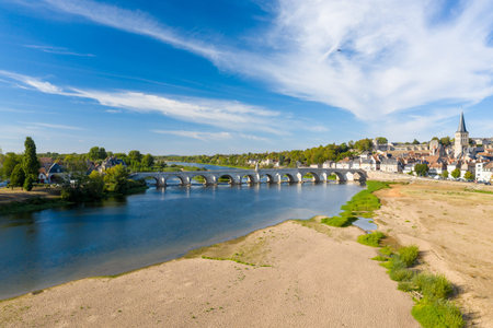 Sweeping view of La Charite sur Loire in central France, featuring a historic stone bridge crossing...