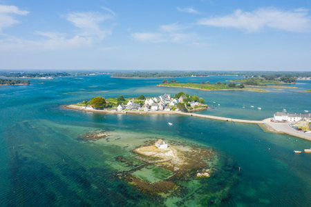 Aerial perspective of a small coastal village on a narrow peninsula with white houses, vibrant...