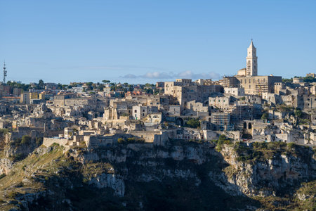 Panoramic view of Matera, Italy, featuring ancient stone buildings and the iconic cathedral tower...