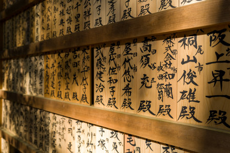 Nara, Japan - November 3, 2023: The image shows a close-up view of wooden plaques with Japanese calligraphy arranged in rows and illuminated by sunlight at a shrine.のeditorial素材