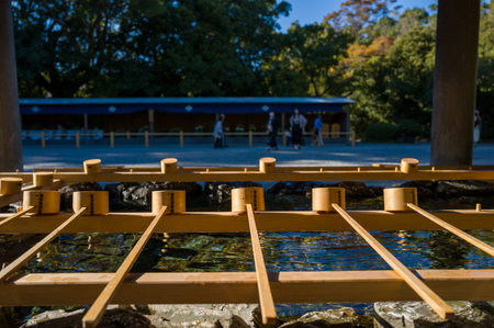 Ise, Japan - October 29, 2023: Wooden ladles are arranged on the wooden frame above the stone basin...