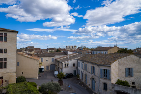 Unknown location - April 2, 2023: Rooftop view over historic stone buildings with tiled roofs, blue...