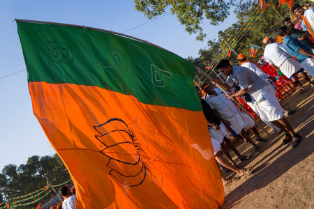 Thrissur, India - March 12, 2023: A group of men hold a large orange and green Bharatiya Janata...