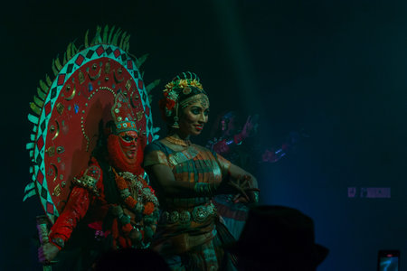 Munnar, India - March 10, 2023: A Theyyam performer in an elaborate red costume with a large...