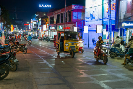 Alappuzha, India - March 7, 2023: An auto rickshaw and several motorcycles travel along a busy...