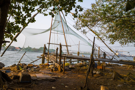 Fort Kochi, India - March 16, 2023: Large Chinese fishing nets are set up along the waterfront with...