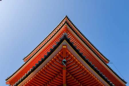 Kyoto, Japan - October 16, 2023: Upward view of the vividly painted wooden eaves and tiled roof of...
