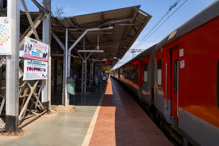 Varkala, India - March 2, 2023: A red passenger train is seen stationary at the platform of Varkala...