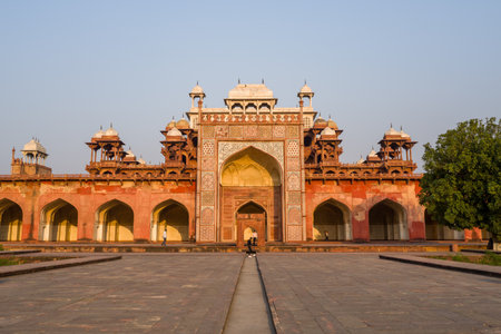 Agra, India - March 12, 2024: The image shows the main entrance gate of Akbars Tomb complex, featuring Mughal architecture with red sandstone, white marble inlay, multiple chhatris, and arched entrances under a clear sky.のeditorial素材