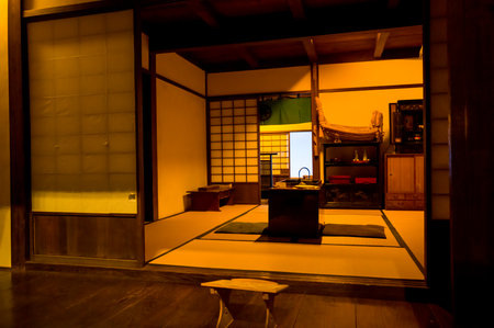 Tokyo, Japan - October 24, 2024: The image shows a reconstructed Edo period tatami room at the Edo Museum, featuring traditional sliding shoji doors, tatami mats, a central hearth, wooden furniture, and period household items under indoor lighting.のeditorial素材