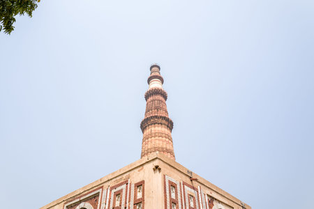 Delhi, India - March 30, 2024: The image shows a low angle view of the Qutub Minar tower rising...