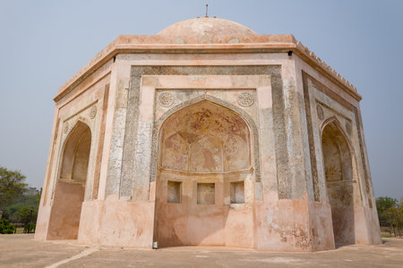Delhi, India - March 30, 2024: The image shows the exterior of the Quli Khan Tomb at the Mehrauli Archaeological Complex, featuring its octagonal structure, arched entrances, and weathered stonework under a clear sky.のeditorial素材