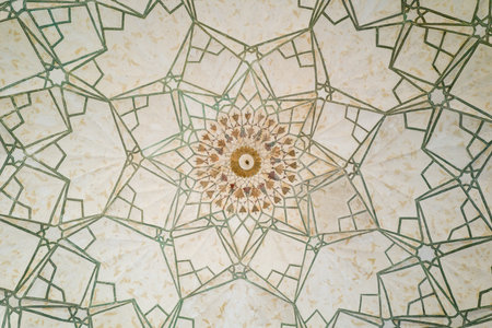Delhi, India - March 29, 2024: The image shows a close-up view of the decorated ceiling at the Naubat Khana in Red Fort, featuring intricate geometric patterns and a central floral motif with visible signs of aging.のeditorial素材