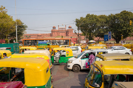Delhi, India - March 29, 2024: The image shows a crowded street scene with numerous yellow and green...