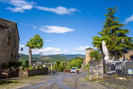 Unknown location - May 6, 2024: View of an outdoor cafe area with tables and chairs, historic stone...