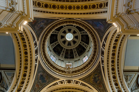 Zaragoza, Spain - May 10, 2024: The ornate interior dome of the Basilica of Nuestra Senora del Pilar is visible with detailed architectural elements, Latin inscriptions, stained glass windows, and painted artwork.のeditorial素材