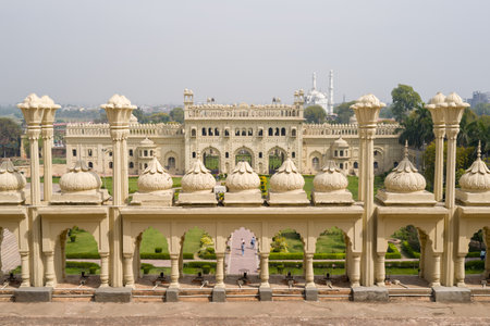 Lucknow, India - March 16, 2024: The image shows a view from the rooftop of the main building of Bara Imambara, featuring decorative domed parapets in the foreground and the central Mughal-style structure with landscaped gardens below under daylight.のeditorial素材