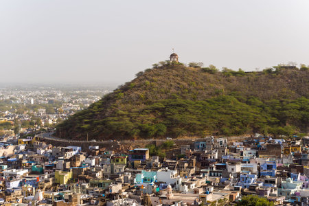 Bundi, India - March 20, 2022: The image shows a densely packed cluster of blue and yellow buildings...