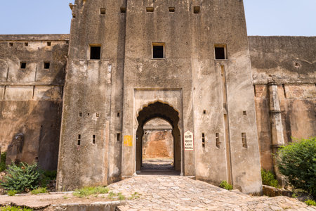 Bundi, India - March 20, 2022: The image shows the main entrance gate of Taragarh Fort with a stone pathway leading through an arched doorway, featuring a sign for Rani Mahal and weathered fort walls under clear daylight.のeditorial素材