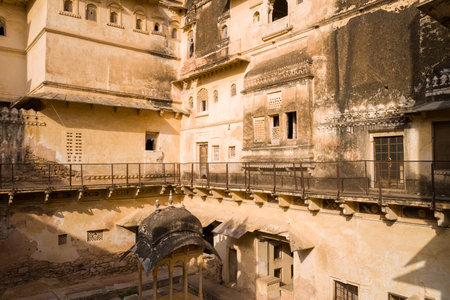 Bundi, India - March 20, 2022: The image shows the inner courtyard of Garh Palace with weathered stone facades, arched windows, decorative latticework, and a small domed pavilion under sunlight.のeditorial素材