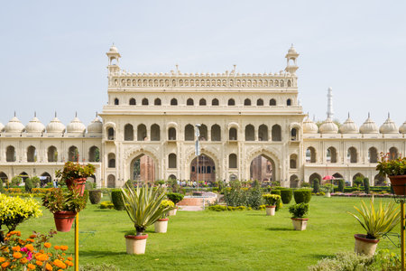 Lucknow, India - March 16, 2024: The image shows the main entrance facade of Bara Imambara, a historic Mughal-style monument, with a landscaped garden and potted plants in the foreground under daylight.のeditorial素材