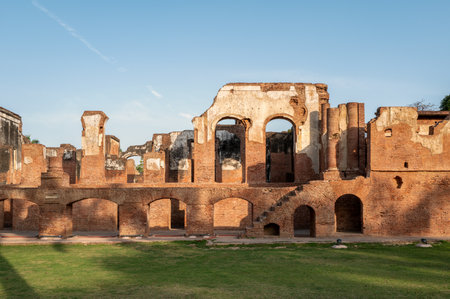 Lucknow, India - March 15, 2024: The image shows a large, ruined colonial-era brick structure with multiple arched openings, damaged upper walls, and an exterior staircase, located at the Residency complex under clear daylight.のeditorial素材