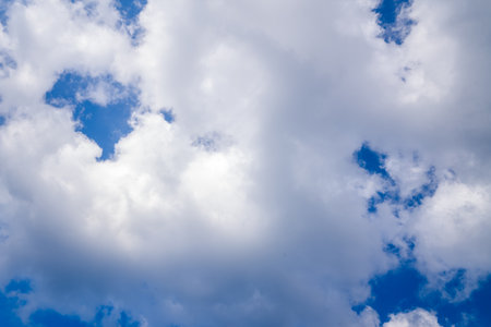 Unknown location - October 21, 2022: Large white clouds with patches of blue sky are visible on a partly cloudy day.のeditorial素材